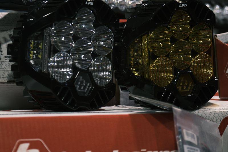 Two Baja Designs LP6 auxiliary lamps and a light bar on their packaging.
