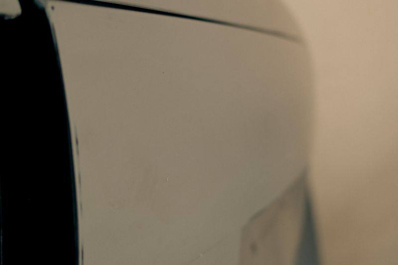 A rear quarter panel and bumper area in primer.