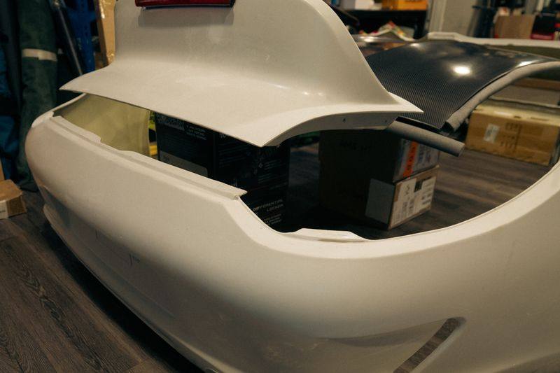 Close view of the rear bumper's ducktail lip and light aperture.