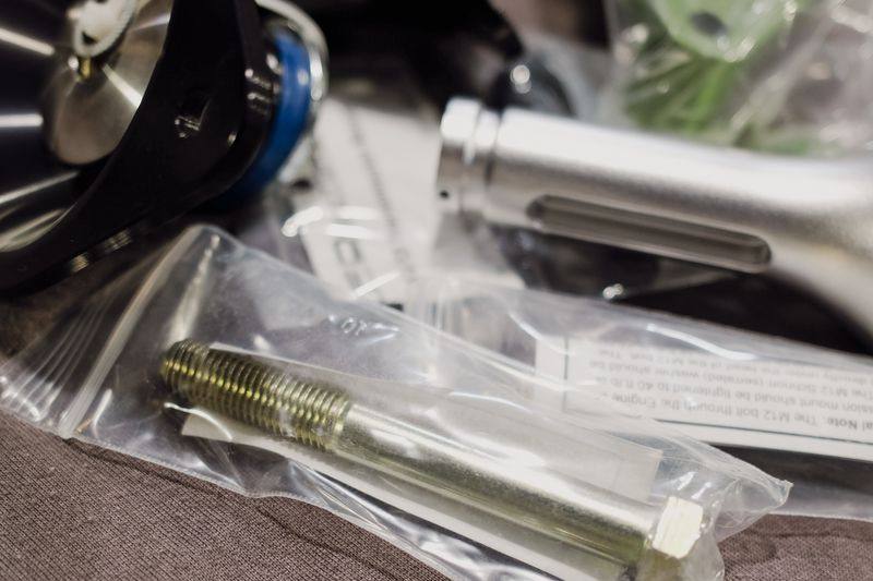 Bagged bolts, studs and a machined spacer alongside the mounts.