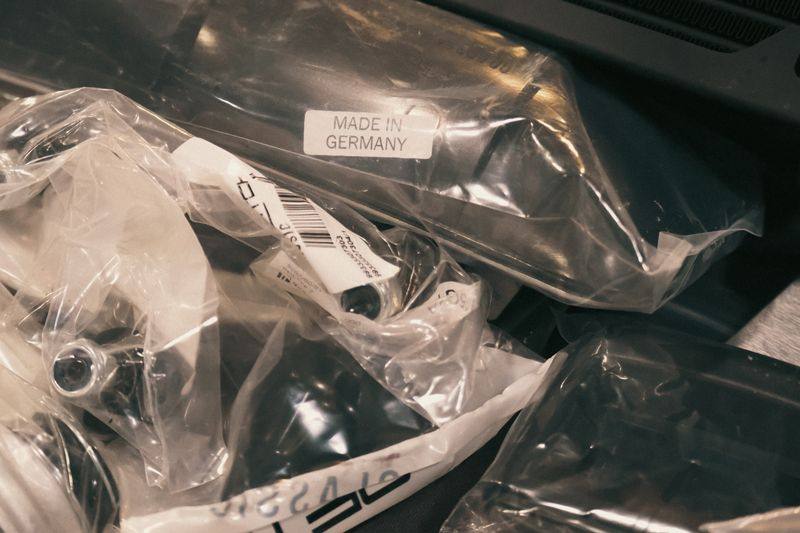 Bagged new parts, one label reading Made in Germany, with a cooler behind.