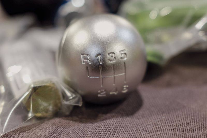 A metal gear knob showing a six-speed shift pattern, R 1 3 5 over 2 4 6.