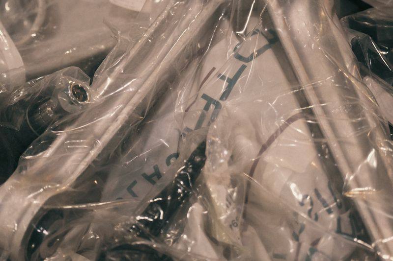 Suspension arms sealed in printed bags, laid out on a dark cloth.